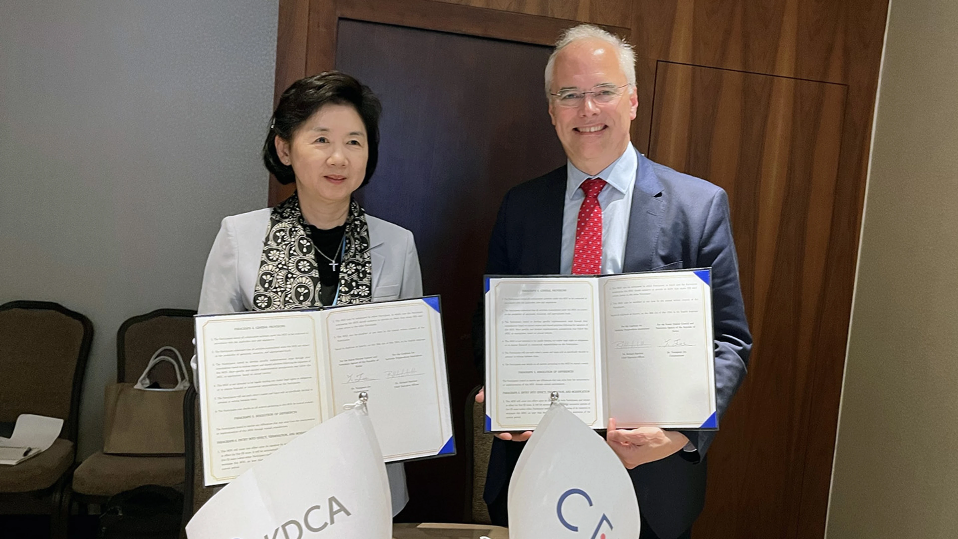 two people holding signed documents to camera